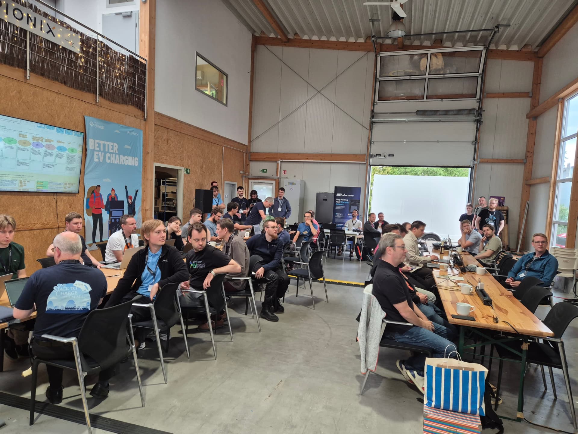 Hackathon kick-off in the hall under the BETTER EV CHARGING banner