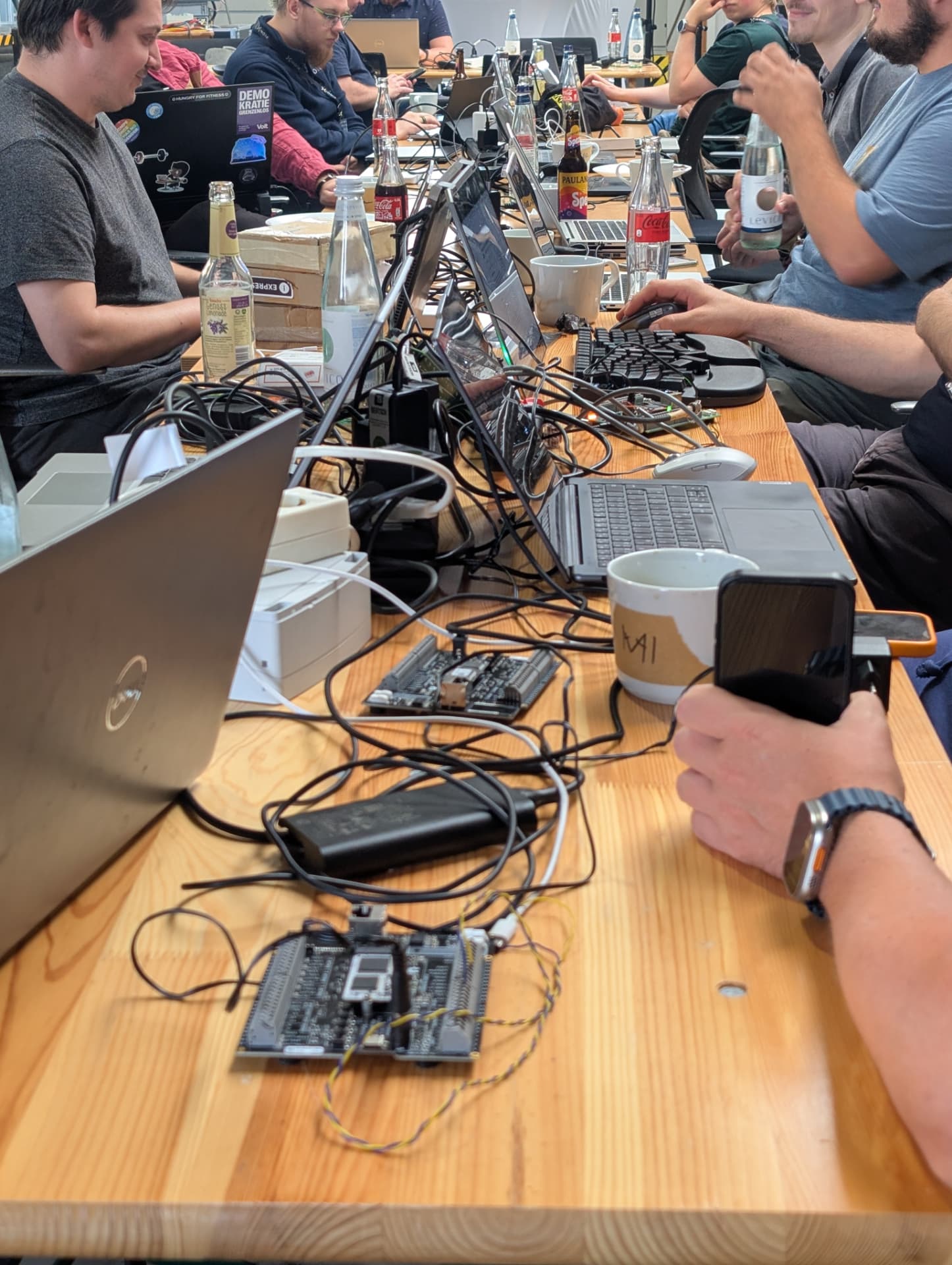 Laptops, circuit boards and cables on a hackathon table