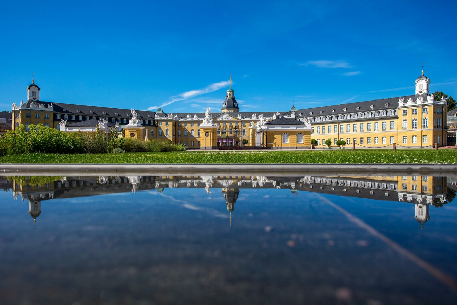 Karlsruhe Palace reflected in water on a sunny day
